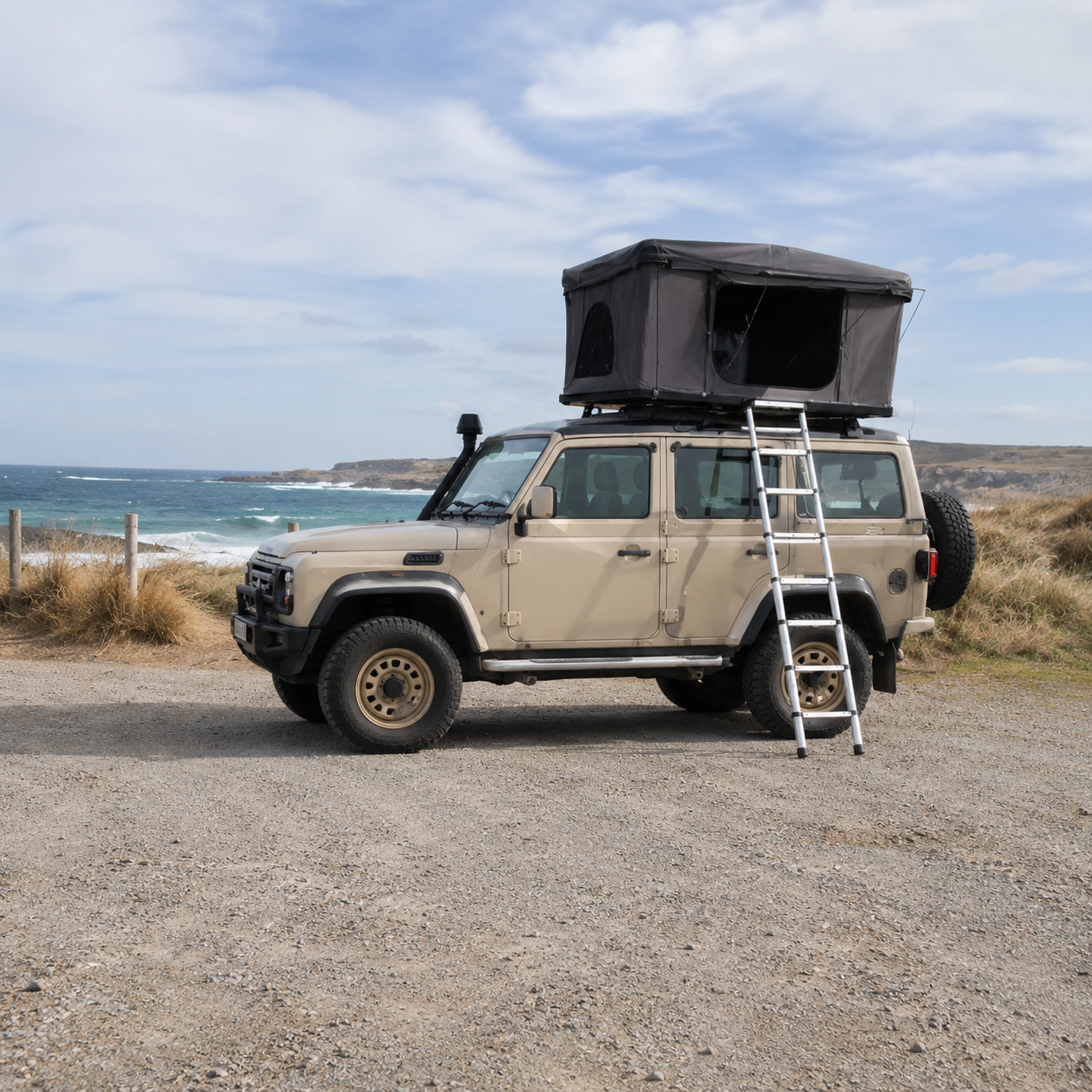 Tente de toit rigide Nomad ouverte sur un véhicule en bord de plage
